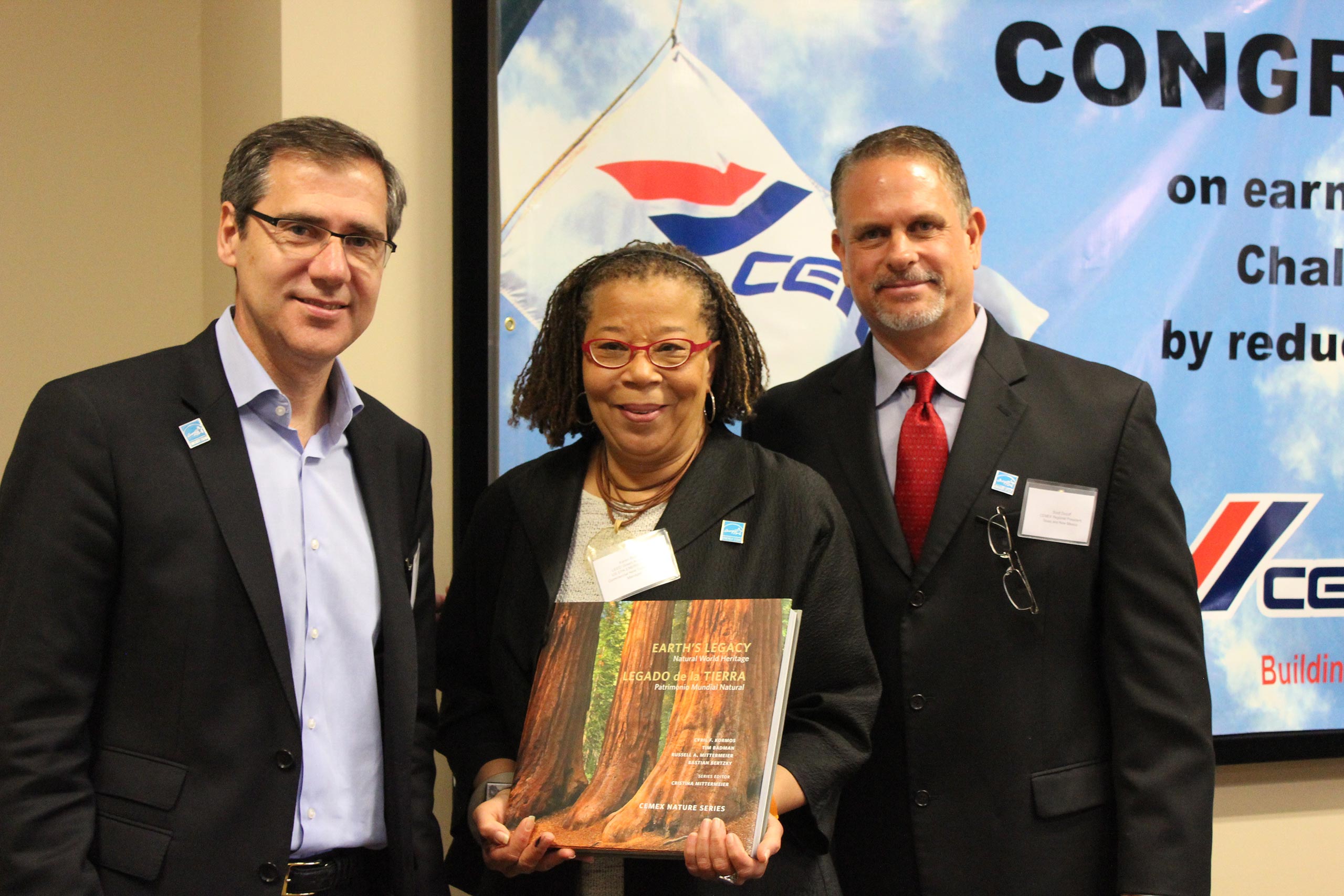 Ignacio Madridejos (left) and Scott Ducoff (right) present Karen Butler (center) with a CEMEX Nature book at an awards ceremony for the 12 Texas ready-mix concrete plants that achieved the EPA ENERGY STAR Challenge for Industry